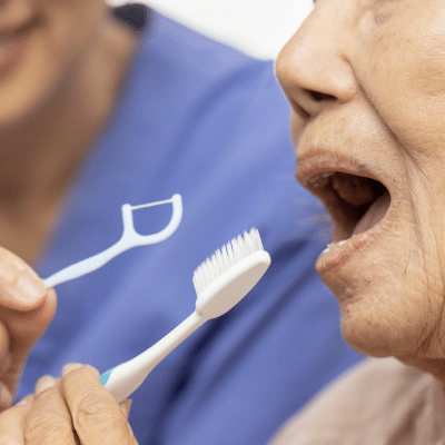 Senior at dentist with mouth open receiving oral health treatment